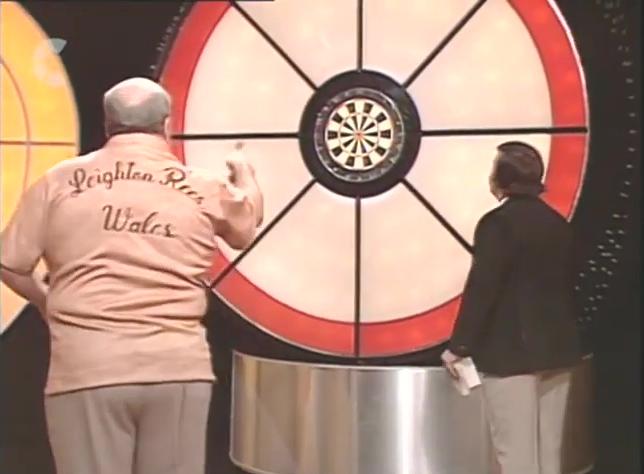 Leighton Rees throwing darts in series 4 of Bullseye, with his back to the camera