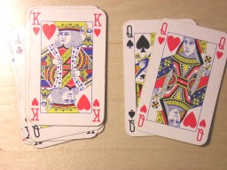 The two cards that were face down are now turned face up to show that they are the queen of spades and the queen of hearts